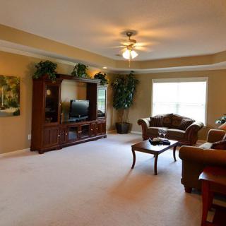 A spacious living room with comfortable seating and a large entertainment center.