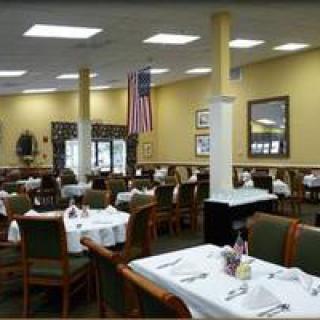 An indoor restaurant dining area with neatly arranged tables and an American flag.