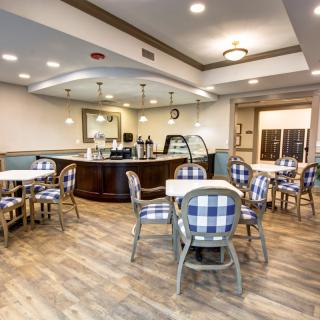 A cozy cafe with checkered chairs, wooden floors, and a coffee counter.
