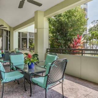 A cozy outdoor patio with comfortable seating and lush greenery.