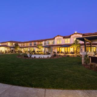 A beautifully lit building exterior at dusk with a well-maintained lawn.