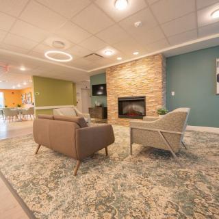 A modern and cozy living room with a stone fireplace and comfortable seating.