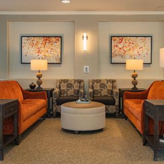 A cozy living room with orange sofas and elegant decor.