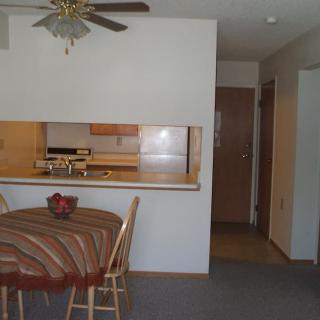 A cozy dining area adjacent to a small kitchen with wooden cabinetry.