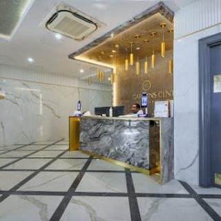 A modern hotel lobby featuring a stylish reception desk with elegant marble and warm lighting.
