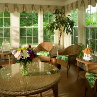 A cozy sunroom with wicker furniture and abundant natural light.