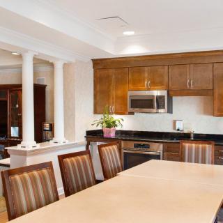 A modern kitchen with wooden cabinets and a dining area featuring a large table and chairs.