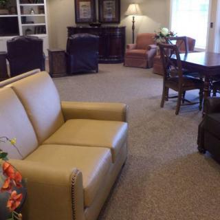 A spacious and well-furnished living room with a sofa, chairs, and a table.