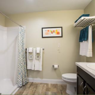 A modern bathroom with a spacious shower, neatly arranged towels, and elegant decor.