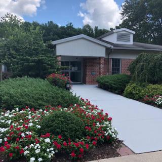 A well-maintained building surrounded by lush gardens and colorful flowers.
