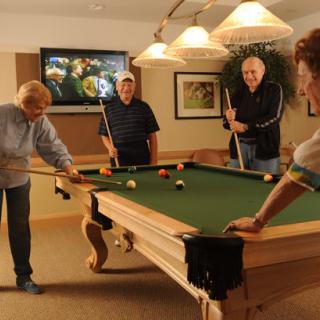 A group of people enjoying a game of billiards indoors.