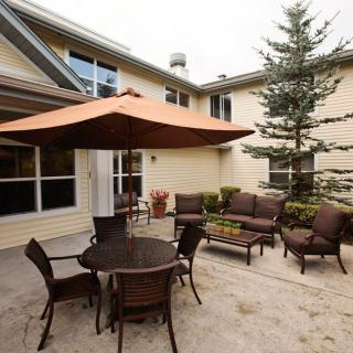 A cozy patio area with an umbrella-shaded table and comfortable chairs.