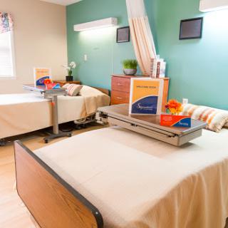 A well-organized patient room in a healthcare facility, featuring two beds and modern amenities.