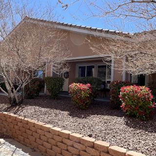 A charming residential house with landscaped front yard and clear blue skies.