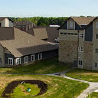 A modern multi-story building surrounded by beautifully landscaped grounds.