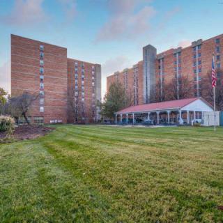 A view of apartment buildings with a large grassy lawn in the foreground.
