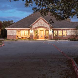 A beautifully lit residential building in the evening, showcasing its architectural design.
