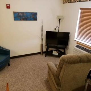 A cozy living room setup with armchairs, a television, and decorative elements.
