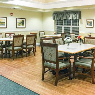 A well-lit dining area with neatly arranged tables and chairs.