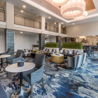A modern lobby with stylish furniture and elegant chandeliers.