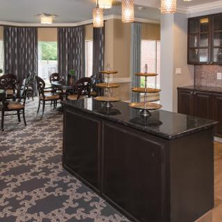 A modern and inviting dining area featuring elegant furniture and a kitchenette.
