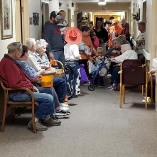A vibrant gathering of individuals in a community center hallway, showcasing social interaction among the elderly.