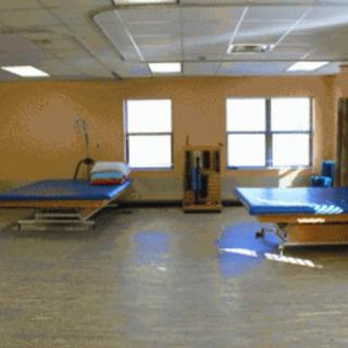 A rehabilitation room equipped with therapy tables and exercise equipment.