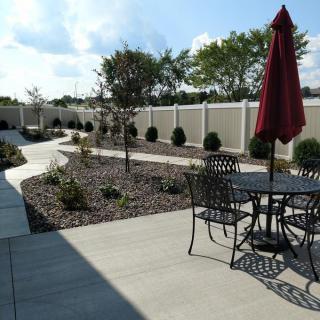 A sunny outdoor patio with garden and pathway.