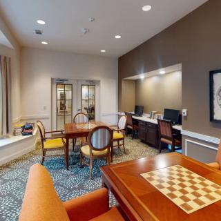 A cozy office space with a seating area, computer workstations, and a chess board.