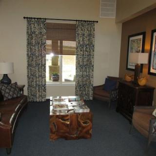 A cozy living room with a sofa, patterned curtains, and a wooden coffee table.