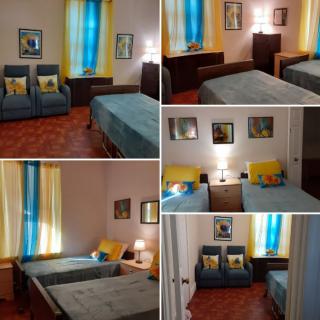 A cozy bedroom featuring twin beds and vibrant blue and yellow curtains.