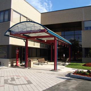 A modern building entrance featuring a colorful canopy.