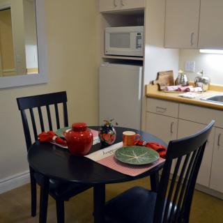 A cozy kitchen with a small dining table set for a meal.