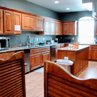 A spacious kitchen featuring wooden cabinets and stainless steel appliances.
