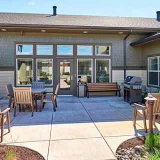 A backyard patio with outdoor seating and a barbecue grill on a sunny day.