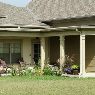 A charming residential house featuring a porch and a well-maintained garden.