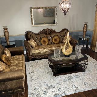 A luxurious living room featuring elegant sofas, a decorative coffee table, and a chandelier.