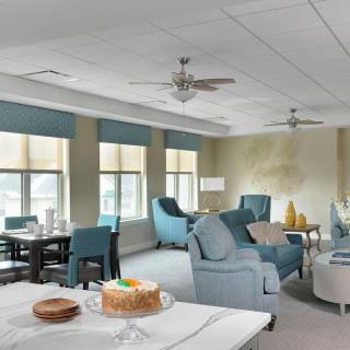 A well-furnished living room with sofas, a table, and a cake on display.