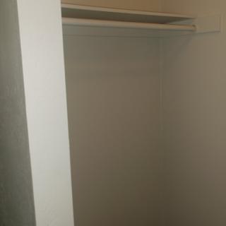 An empty closet with a shelf and hanger rod.