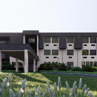 A modern building with a sleek design, surrounded by lush greenery.