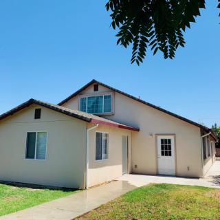 A sunny day view of a residential house with a small front yard.
