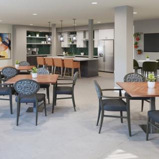 A modern dining area with seating arrangements and a kitchen in the background.