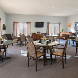 A spacious and well-lit dining area featuring elegant furniture and a cozy atmosphere.
