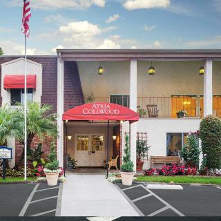 Exterior view of a hotel entrance with red awning and American flag.