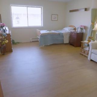 A clean and minimalist hospital room with a single bed and window.