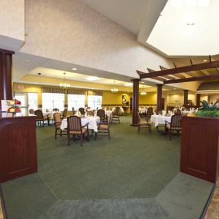 A spacious dining area with tables and chairs, occupied by several people enjoying a meal.
