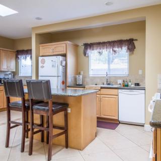 A spacious kitchen with an island and bar stools.