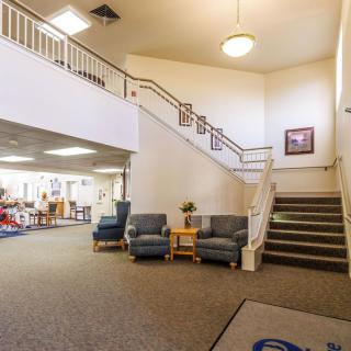 A spacious lobby with seating and a staircase leading to an upper level.