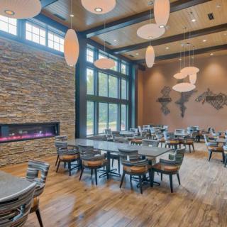 A modern dining area with a stylish fireplace, large windows, and elegant lighting.