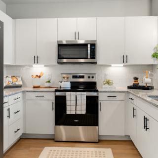 A modern kitchen featuring sleek white cabinets and stylish appliances.